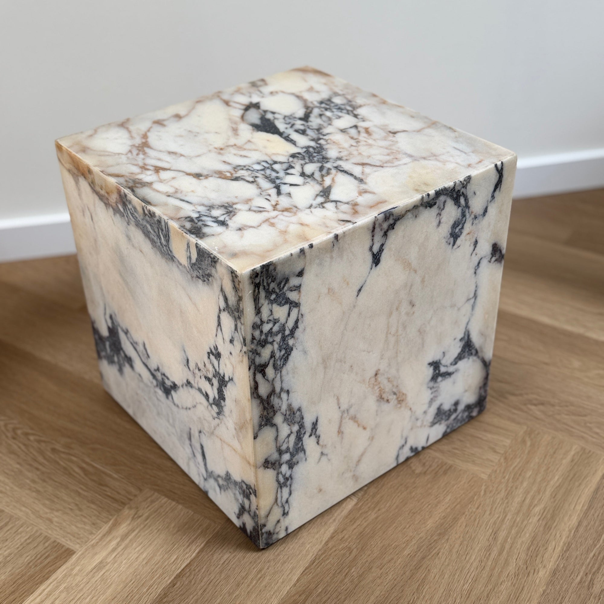 Marble cube on a wooden floor with a neutral background